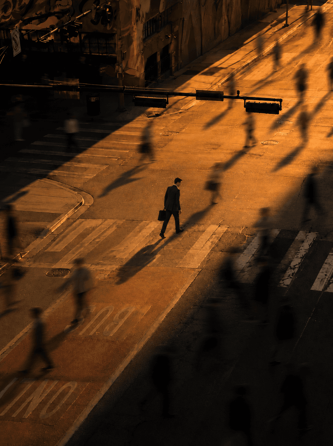Commuters crossing an intersection in golden light